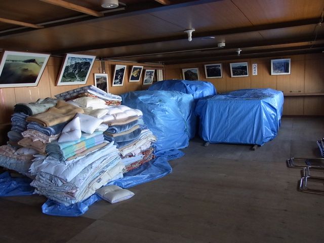 小屋閉め準備。各客室の布団を越冬させるため、山にしてブルーシートで包みます 