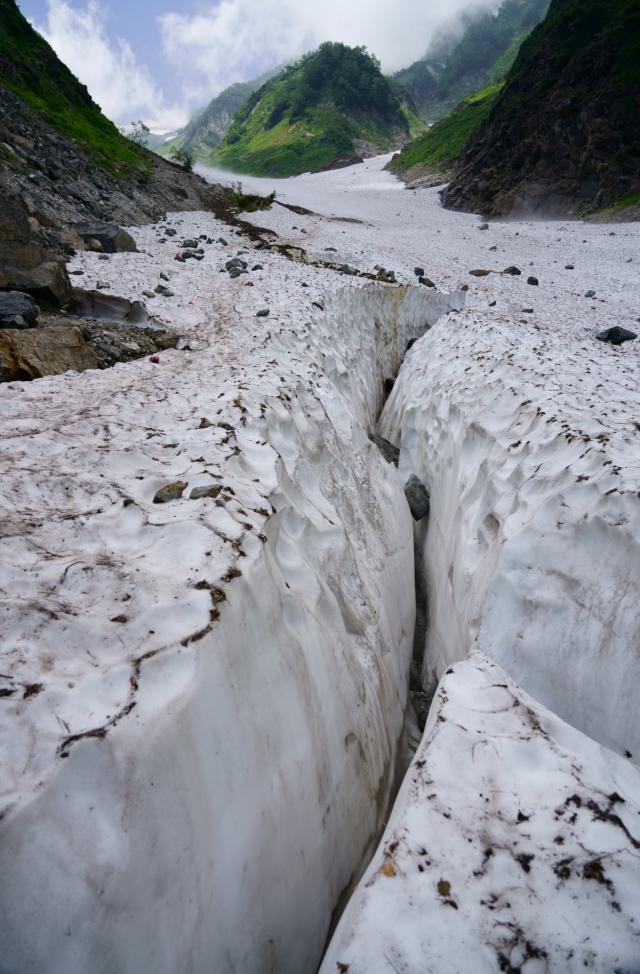 大雪渓へ下り立つとすぐに、クレバス地帯を避けてすり抜けていくようなコースどりになっています。赤布を目印に慎重に通過を