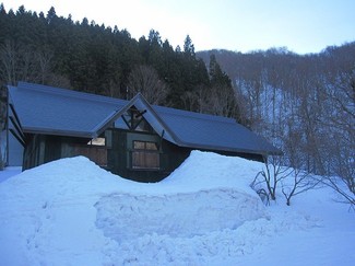 屋根まで届きそうな雪が-１階部分は完全に雪に埋もれています