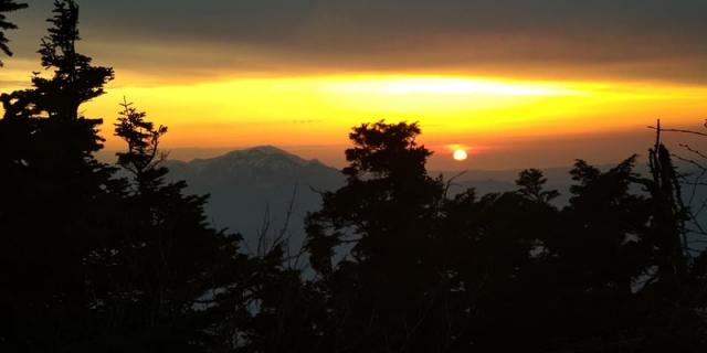 今日の夕陽。木々の間からは越後駒ケ岳。越後駒ケ岳の手前に荒沢岳も見えています。