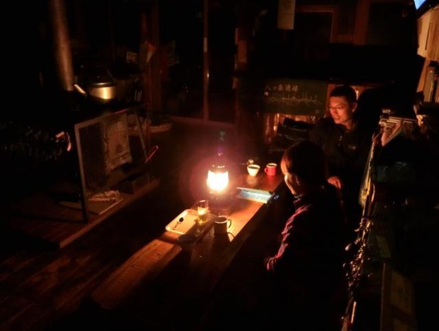 夜、ランプの灯りの下、小屋の薪ストーブ前でのかたらい