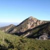 朝、西天狗岳と根石山荘（手前）。左奥には北アルプスが見える 