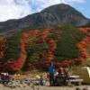紅葉の中にぎわう雷鳥沢キャンプ場。奥は浄土山 