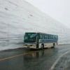 雪の大谷を走るバス