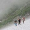 小雪渓のトラバースルートを歩く登山者 