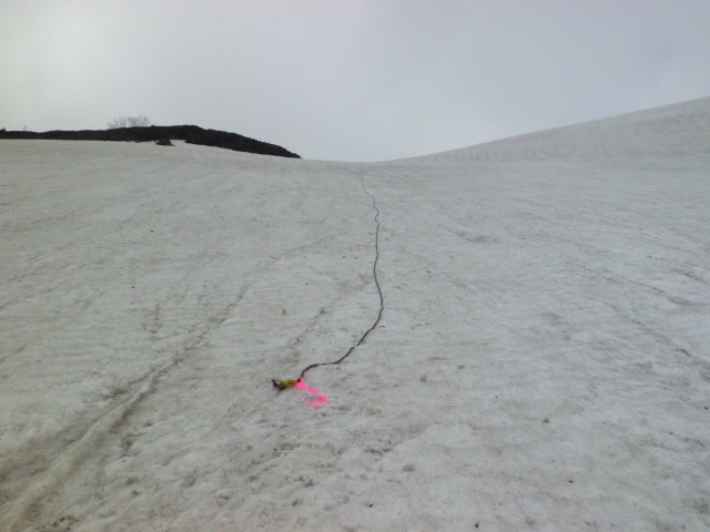 乗鞍岳の雪渓にはルート誘導用の補助ロープがありそのロープ横を登ります。30度以上の傾斜でアイゼンが必要です。下部にはすでに岩も出ていますので慎重に登りましょう。
