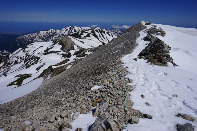 1-白馬頂上から先の登山道の富山側の雪はだいぶ解けていますが、信州側にはまだたっぷりと残っています。（画面左奥、雪倉岳・朝日岳がよく見えています。）