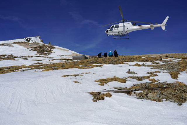 ヘリコプターから降り立ったスタッフと白馬岳頂上と貞逸碑