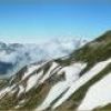 山荘前より唐松岳と剱岳　昨日まで、視界の悪い日続きでした。久し振りの晴天。唐松岳の山肌には、濃緑のハイマツ葉が広がり、白い残雪は日ごとに消えて小さくなっていきます。