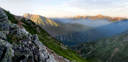 朝陽に輝く五竜岳と剱岳です。快晴の朝を迎えました。牛首の登山道上よりの眺望です。