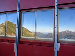 窓に映りこむ唐松岳。唐松岳頂上山荘の食堂の窓一面に映りこむ、唐松岳～剱立山連峰の山並みです。