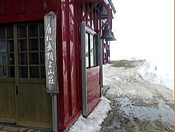 唐松岳頂上山荘の玄関の様子　小屋前に雪はみえませんが、回りは全面雪です。