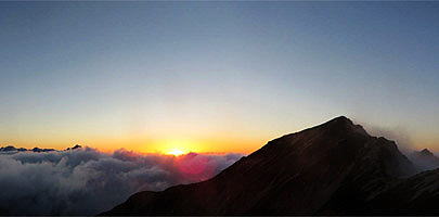 唐松岳のシルエット　雲海の中へと太陽が沈みます。
