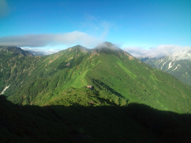 朝日が当たりだした新越山荘と鳴沢岳(右)と赤沢岳（左） 