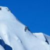 頂上までもう少し、鹿島槍ダイレクト尾根の核心部を越え、残された最後の雪稜を登る登山者が２人、尾根の右下に点になって見える
