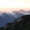 水晶岳の少し北に沈む夕日と烏帽子岳の滝雲 