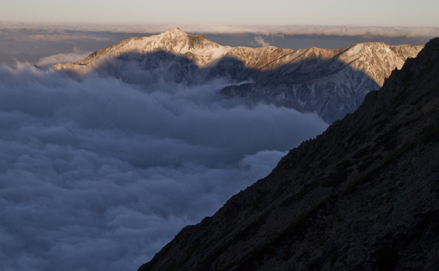 新雪の笠ヶ岳と穂高の山影 