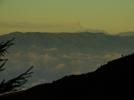 噴煙上がる御嶽山。手前雲海の彼方に美ヶ原の電波塔が見られます。